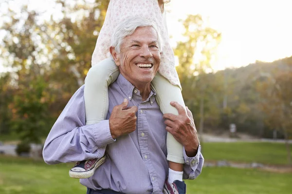 Grootvader geven kleindochter schouder rit — Stockfoto