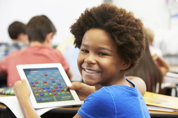Alumno en clase jugando un juego en una tableta —  Fotos de Stock