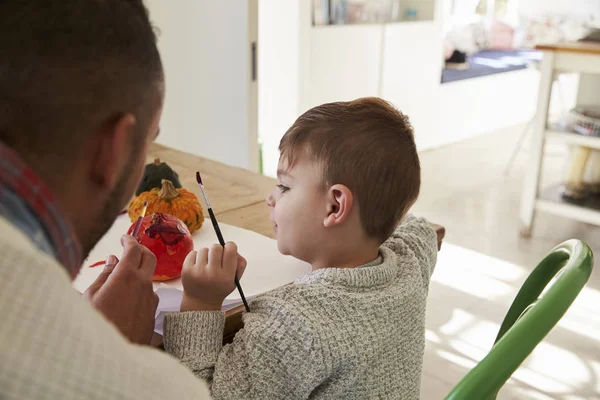 Vader en zoon Halloween pompoenen versieren — Stockfoto