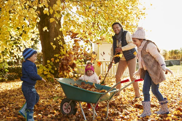 Crianças ajudando os pais a coletar folhas — Fotografia de Stock