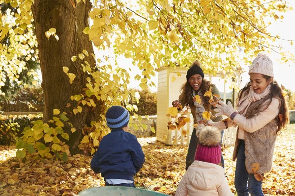 Kinder helfen Eltern beim Laubsammeln — Stockfoto