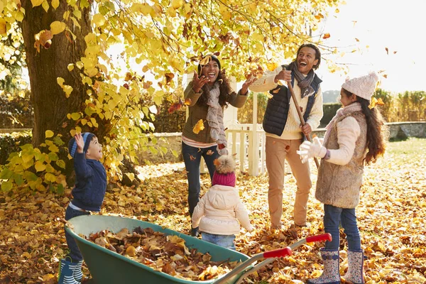 Barn hjälper föräldrar att samla löv — Stockfoto