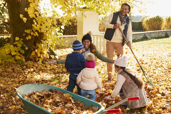 Kinder helfen Eltern beim Laubsammeln — Stockfoto