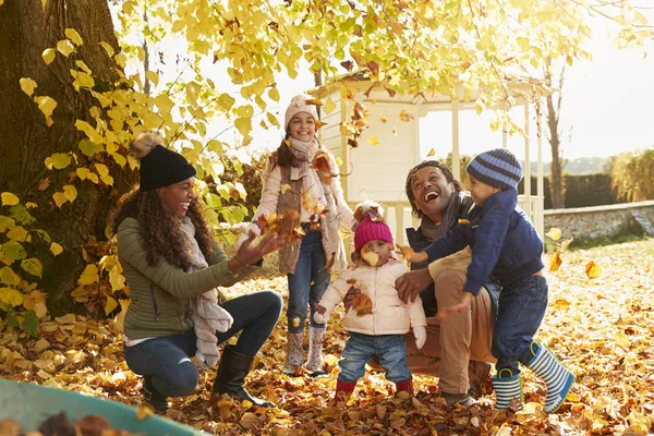 Kinderen helpen ouders voor het verzamelen van bladeren — Stockfoto