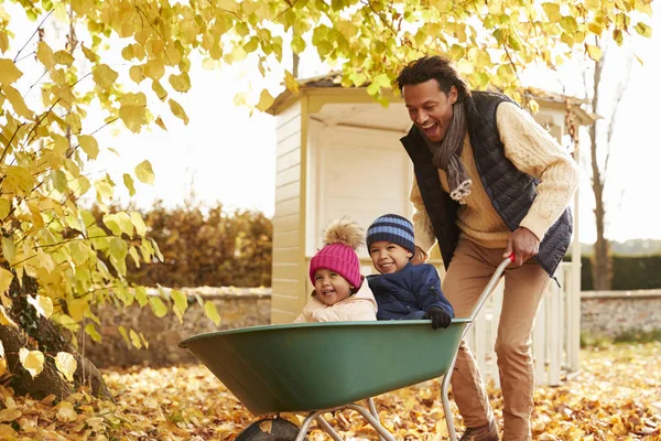 Vater lässt Kinder in Schubkarre fahren — Stockfoto