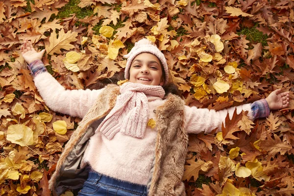 女孩躺在秋天的树叶 — 图库照片