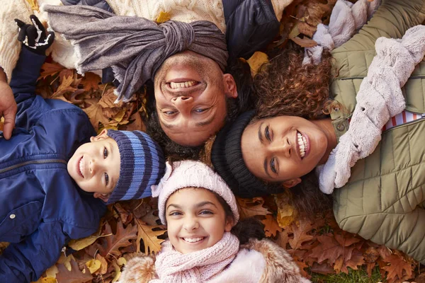 Familie liggen In de herfst bladeren — Stockfoto