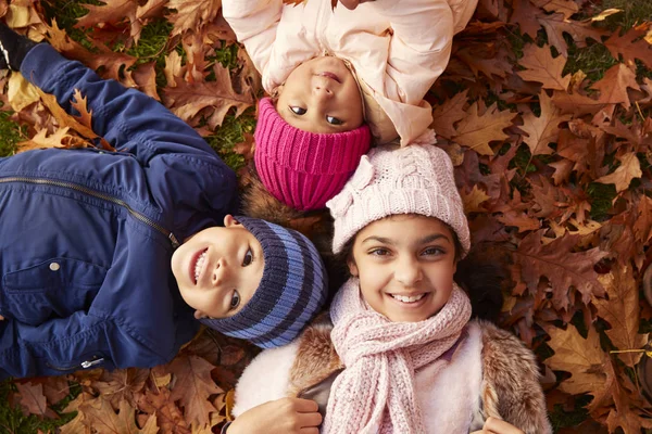 Les enfants allongés dans les feuilles d'automne — Photo