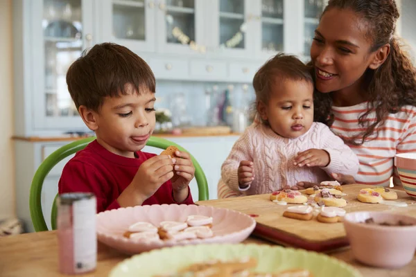 Mãe e crianças decorando biscoitos — Fotografia de Stock