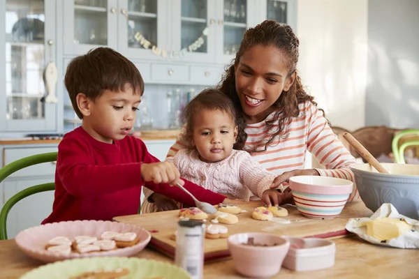 Mãe e crianças decorando biscoitos — Fotografia de Stock