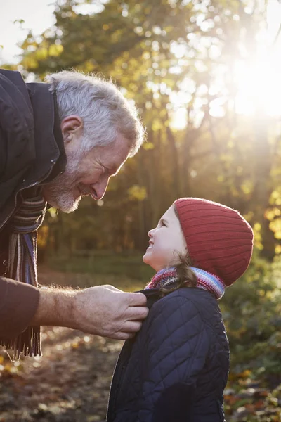 Großvater bindet Enkelinnen Schal — Stockfoto