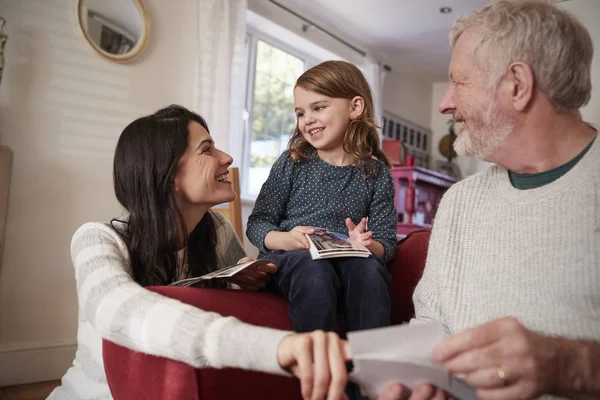 Familia en casa mirando fotografías — Foto de Stock