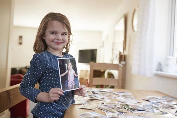 Ung flicka tittar på familjens fotografier — Stockfoto