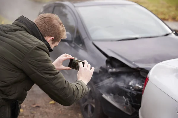 Hombre tomando fotos de accidente de coche — Foto de Stock
