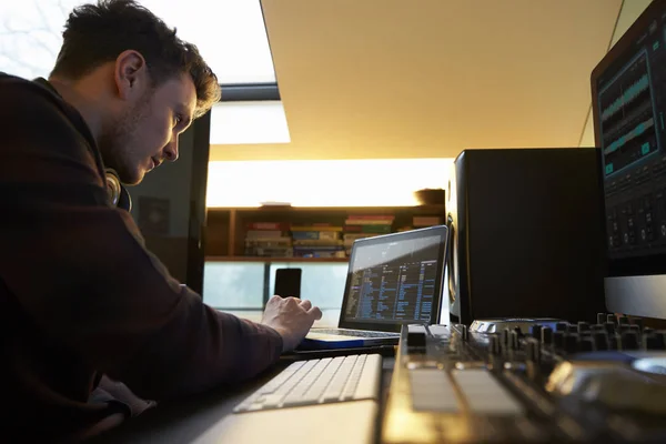 A fiatalember alkotó zene a hordozható számítógépet a hálószobában — Stock Fotó