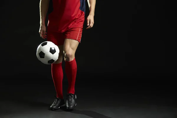 Fechar-se de jogador de futebol profissional com bola no estúdio — Fotografia de Stock