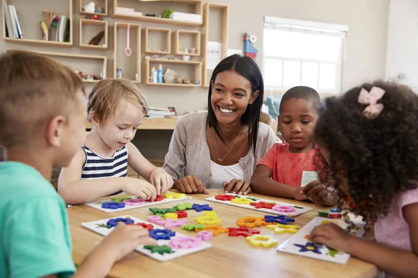 Nauczyciel i uczniowie w szkole Montessori — Zdjęcie stockowe