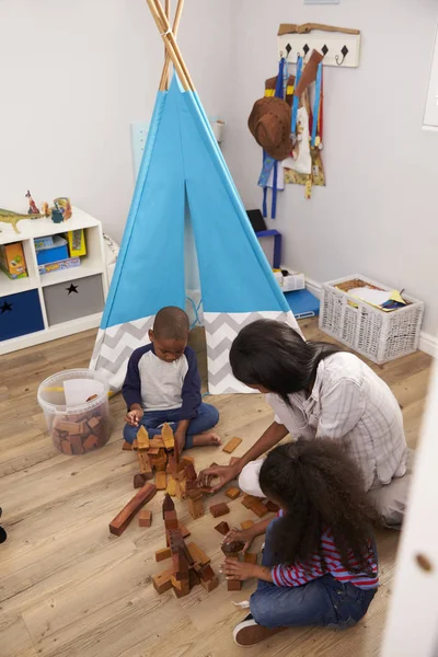 Madre e hijos jugando en el dormitorio — Foto de Stock