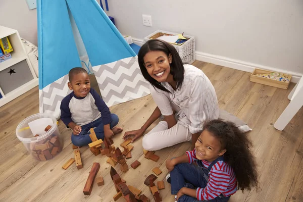 Matka a děti si hrají v ložnici — Stock fotografie