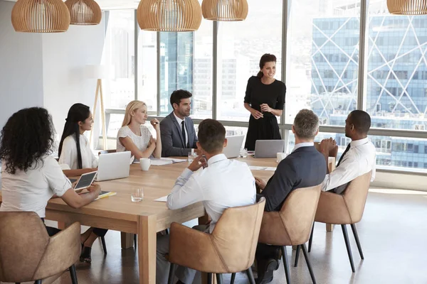 Empresária se levanta para abordar reunião — Fotografia de Stock
