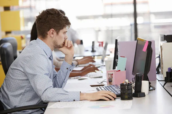 Young white man working at computer — Stock Photo, Image