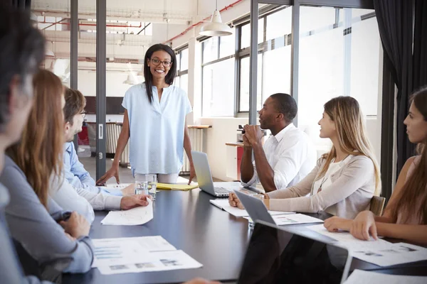 Vrouw staat aanpakken van collega's tijdens vergadering — Stockfoto