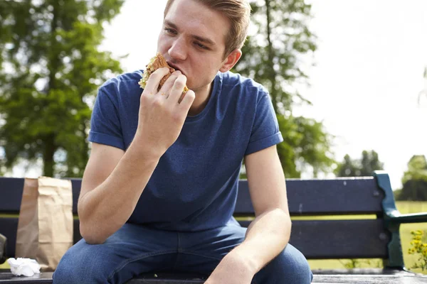 Joven comiendo hamburguesa — Foto de Stock