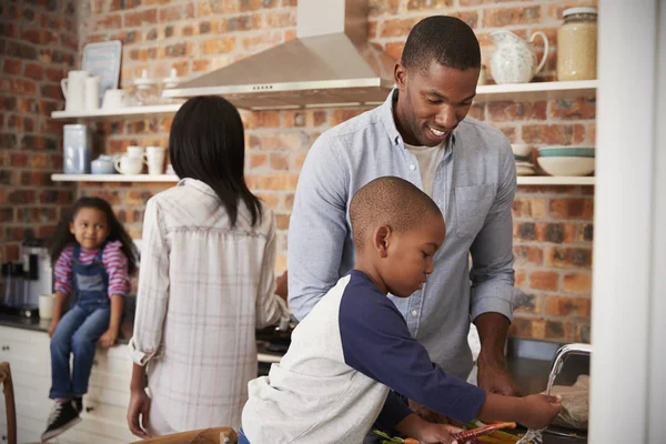 Crianças ajudando os pais na cozinha — Fotografia de Stock