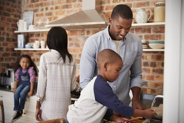 Niños ayudando a los padres en la cocina — Foto de Stock