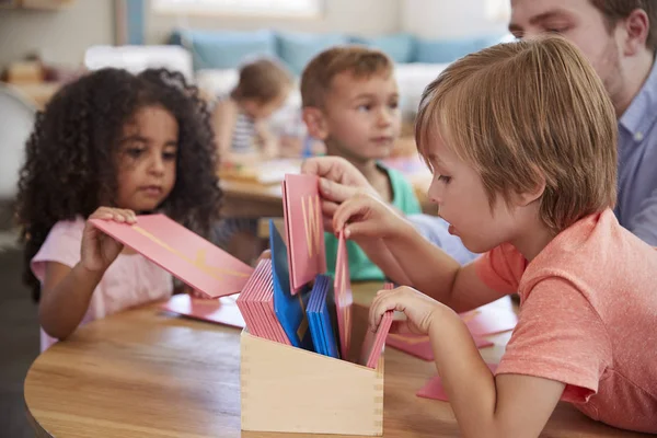 Nauczyciel i uczniowie w szkole Montessori — Zdjęcie stockowe