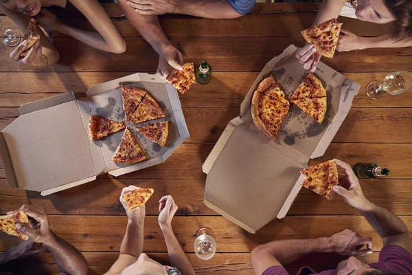 Amigos à mesa compartilhando pizzas — Fotografia de Stock