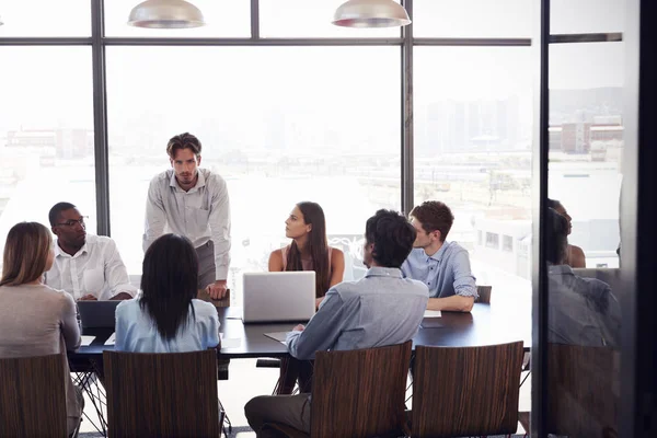 Man stands addressing team — Stock Photo, Image