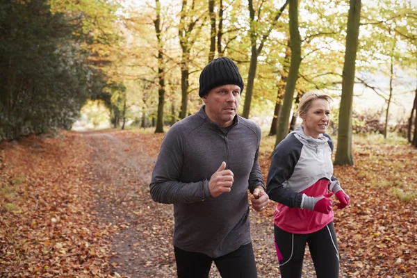 Couple Running Through Autumn Woodland — Stock Photo, Image