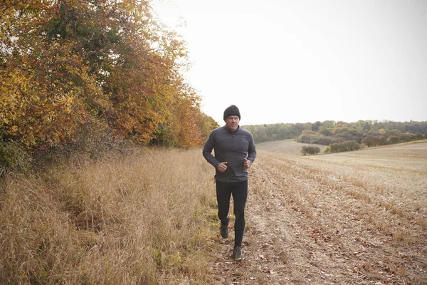 Mann läuft durch Herbstfeld — Stockfoto