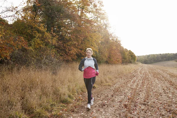 Frau läuft durch Herbstfeld — Stockfoto