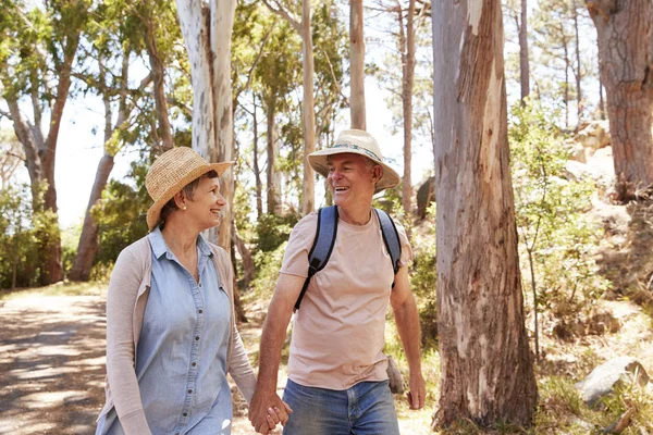 Ouder paar wandelen langs bos — Stockfoto