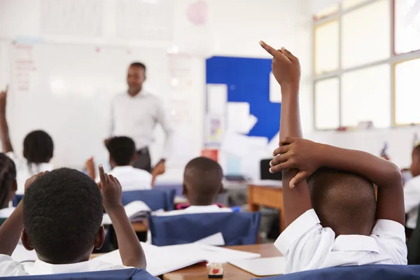 Bambini alzando le mani per rispondere insegnante — Foto Stock