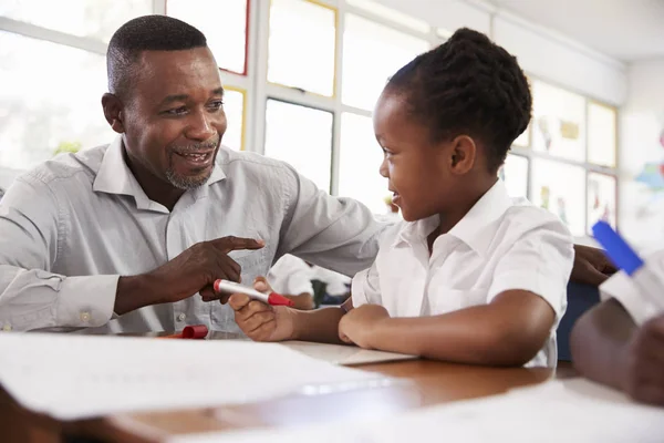 Professeur aider la fille au bureau — Photo