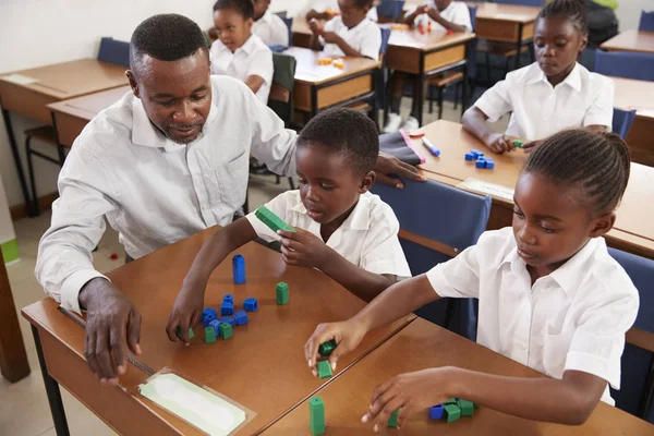 Insegnante aiutare i bambini a contare con i blocchi — Foto Stock