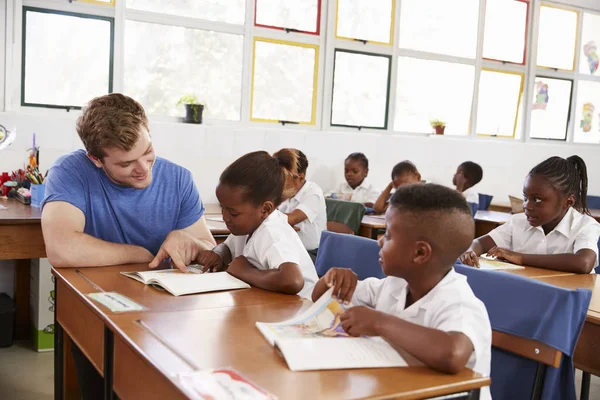 Professeur aider jeune fille au bureau — Photo