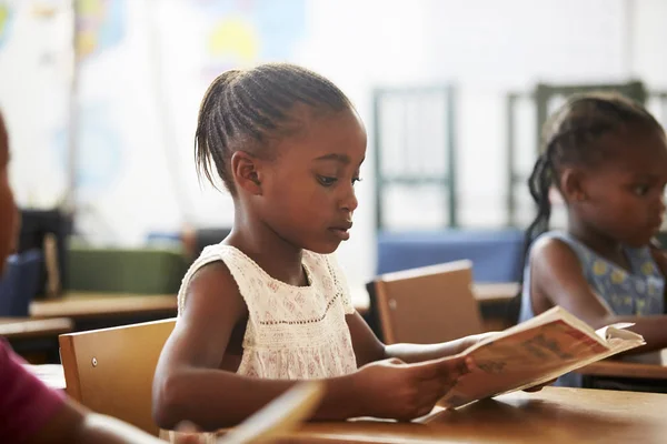 Menina segurando livro e leitura — Fotografia de Stock