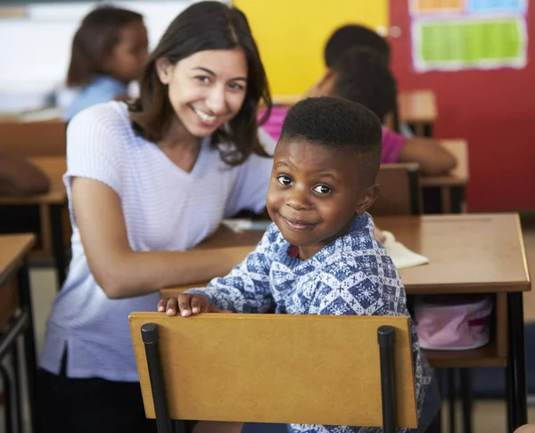 Maestro y niño sonriendo a la cámara — Foto de Stock