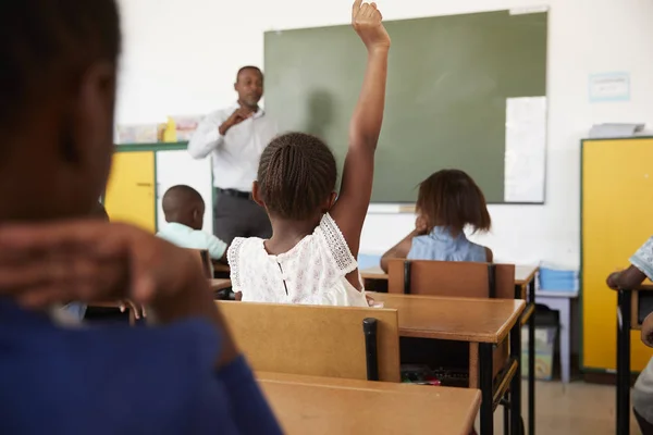 Bambini con le mani in alto nella classe scolastica — Foto Stock