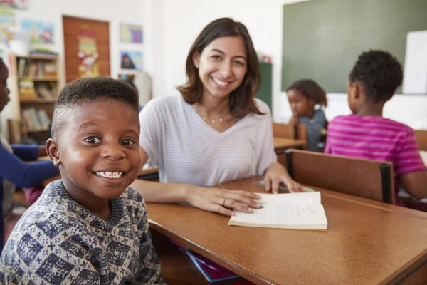 Öğretmen ve okul çocuk kameraya gülümseyen — Stok fotoğraf
