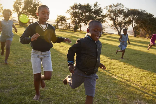 School kids running in field — Stock Photo, Image