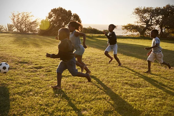 Crianças da escola jogando futebol no campo — Fotografia de Stock