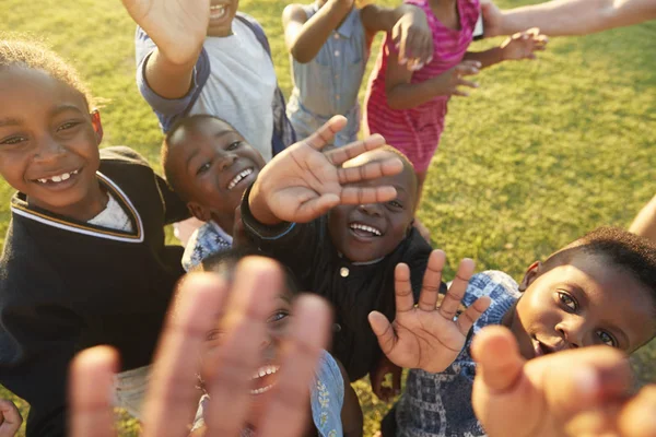 Anak-anak sekolah melihat ke kamera dan melambaikan tangan — Stok Foto