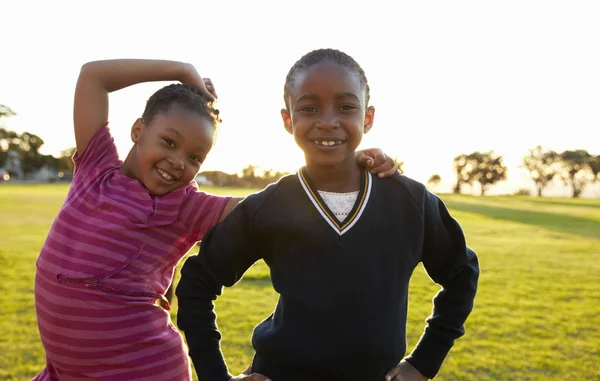 Schoolmeisjes poseren voor camera in veld — Stockfoto