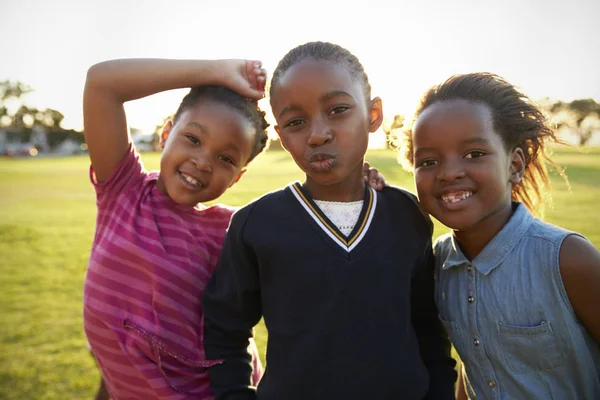 Schoolmeisjes poseren voor camera in veld — Stockfoto