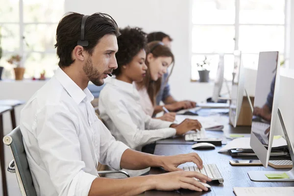 Mann mit Headset arbeitet am Computer — Stockfoto